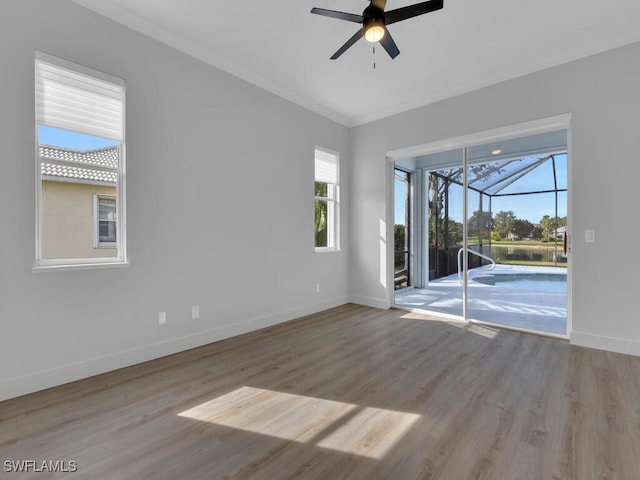 empty room featuring crown molding, ceiling fan, and light wood-type flooring