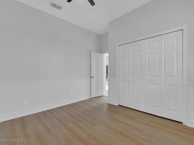 unfurnished bedroom featuring ceiling fan, light hardwood / wood-style floors, and a closet