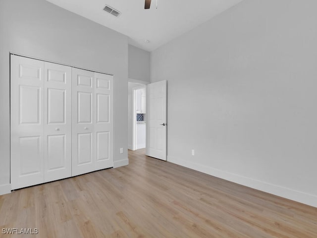 unfurnished bedroom with light hardwood / wood-style flooring, a closet, and ceiling fan