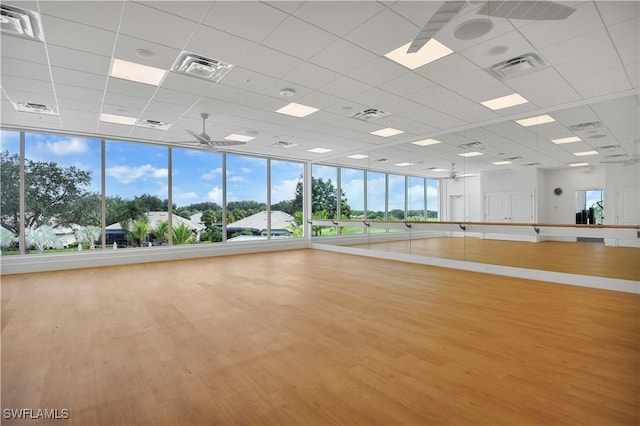 workout area featuring hardwood / wood-style flooring, a paneled ceiling, and ceiling fan