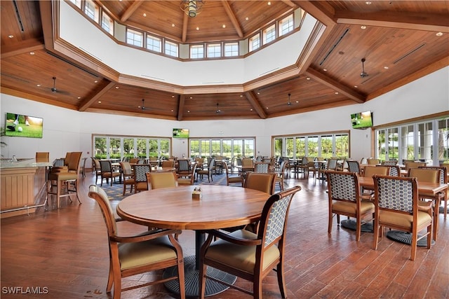 dining space with wood ceiling, plenty of natural light, hardwood / wood-style flooring, and a high ceiling