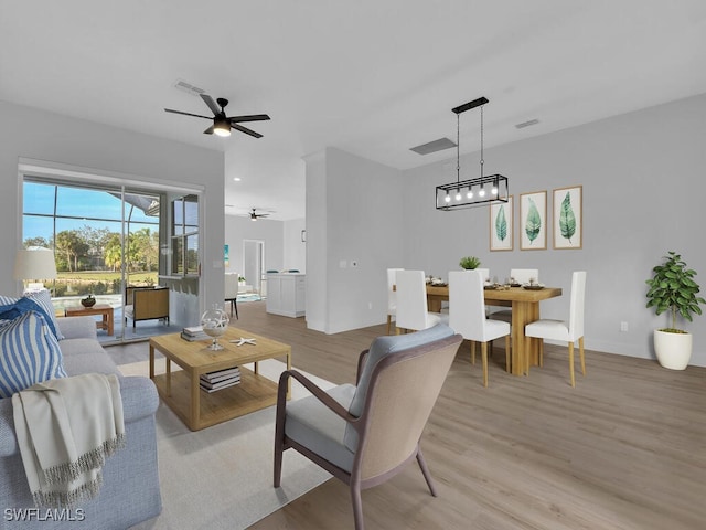 living room featuring ceiling fan and light hardwood / wood-style flooring