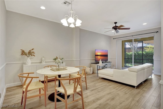 dining space featuring ceiling fan with notable chandelier and light hardwood / wood-style floors