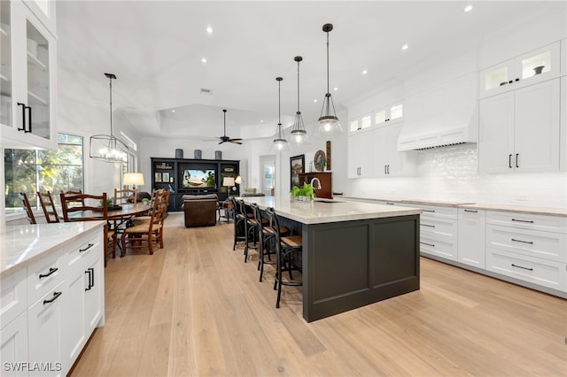 kitchen featuring white cabinetry and an island with sink