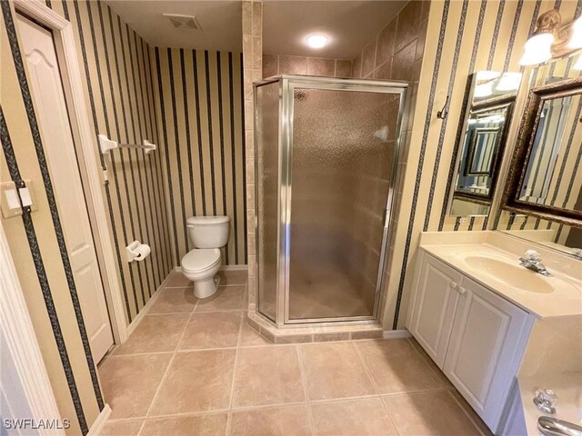 bathroom featuring vanity, an enclosed shower, tile patterned floors, and toilet