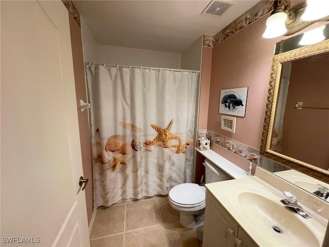 bathroom with tile patterned flooring, vanity, and toilet