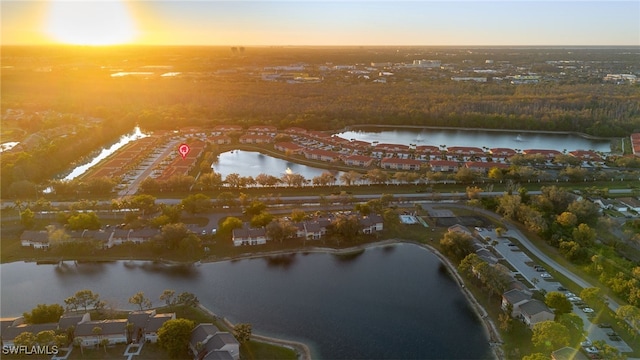 aerial view at dusk featuring a water view