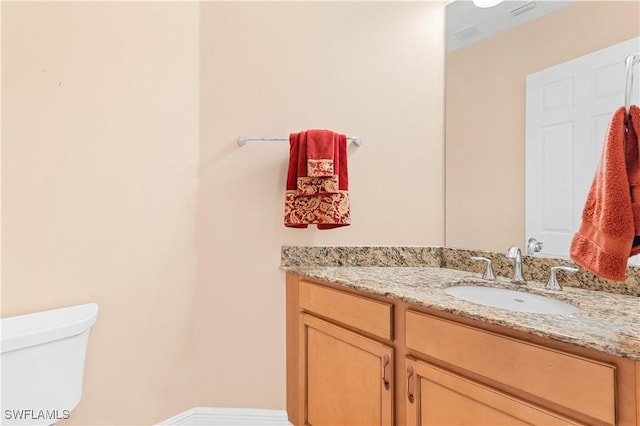 bathroom featuring vanity and toilet