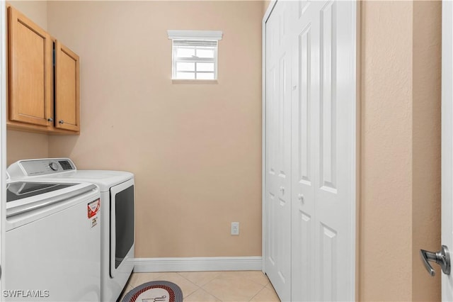 washroom featuring light tile patterned flooring, cabinets, and washing machine and dryer