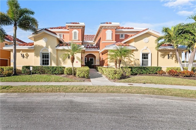 mediterranean / spanish-style house featuring a front yard