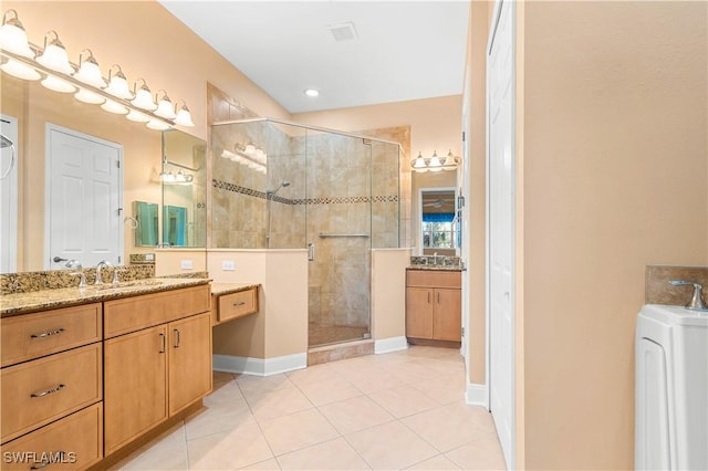 bathroom featuring walk in shower, tile patterned floors, washer / clothes dryer, and vanity