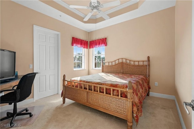 carpeted bedroom with crown molding and a raised ceiling