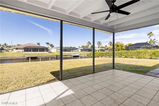 sunroom featuring ceiling fan, a wealth of natural light, beamed ceiling, and a water view