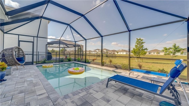 view of swimming pool featuring a lanai and a patio