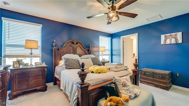 carpeted bedroom with multiple windows and ceiling fan