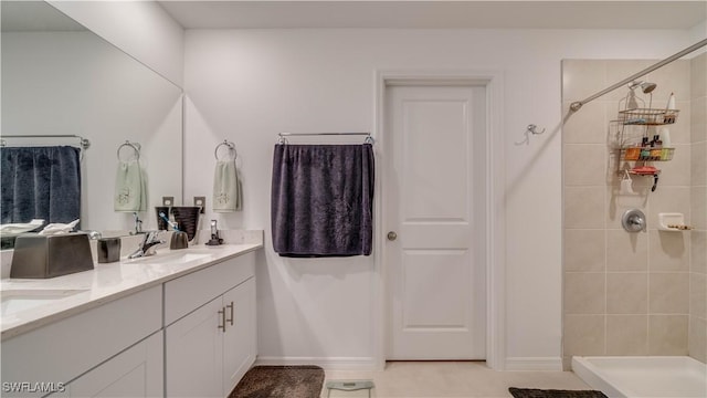 bathroom with vanity and a tile shower