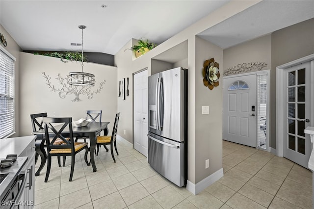 kitchen with lofted ceiling, stainless steel fridge with ice dispenser, hanging light fixtures, and light tile patterned floors