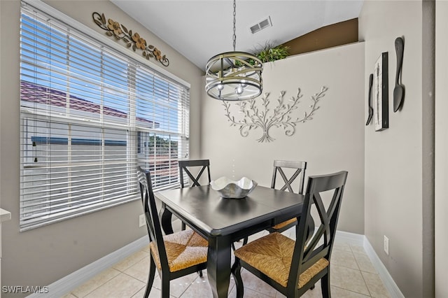 tiled dining area with a chandelier