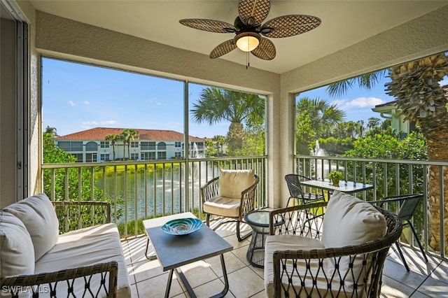 sunroom / solarium with a water view and ceiling fan