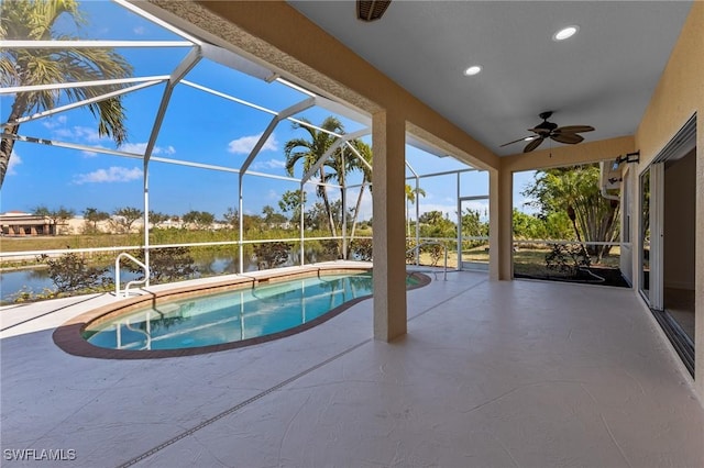 view of pool featuring a lanai, a patio area, ceiling fan, and a water view