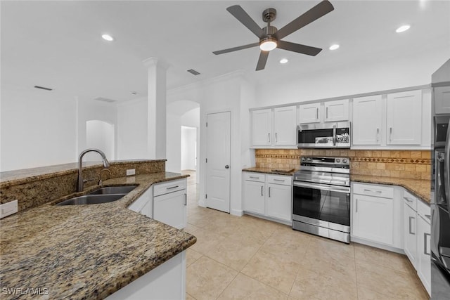 kitchen featuring sink, dark stone counters, white cabinets, and appliances with stainless steel finishes