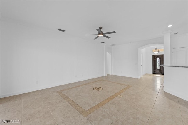 tiled empty room featuring ornamental molding and ceiling fan