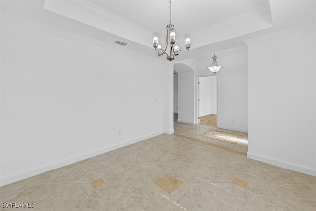 spare room with crown molding, a raised ceiling, and an inviting chandelier