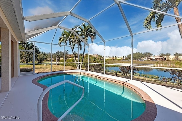 view of pool with a lanai, a patio area, and a water view