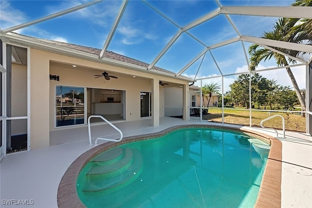 view of swimming pool featuring a patio, ceiling fan, and glass enclosure