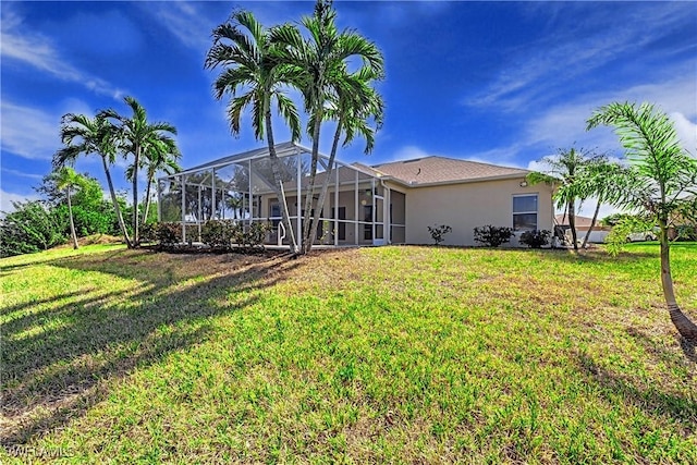 back of property with a lanai and a lawn