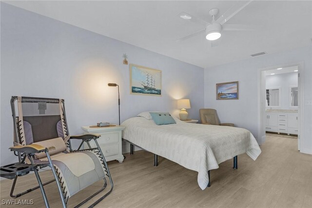 bedroom featuring ensuite bath, light hardwood / wood-style flooring, and ceiling fan