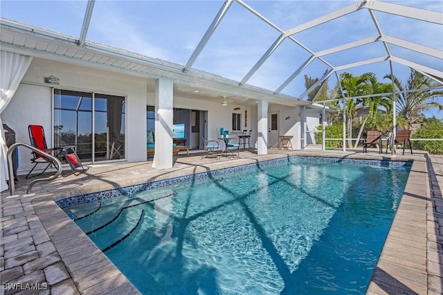 view of pool with ceiling fan, a lanai, and a patio area