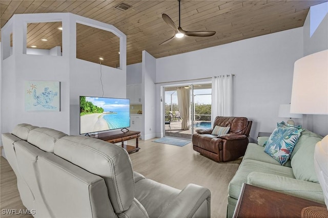 living room with a towering ceiling, wooden ceiling, light hardwood / wood-style floors, and ceiling fan