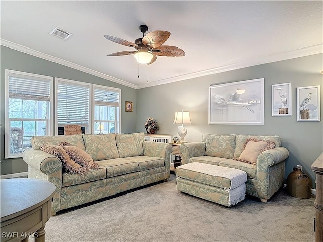 carpeted living room with ornamental molding and ceiling fan