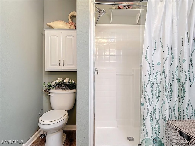 bathroom with hardwood / wood-style flooring, toilet, and walk in shower