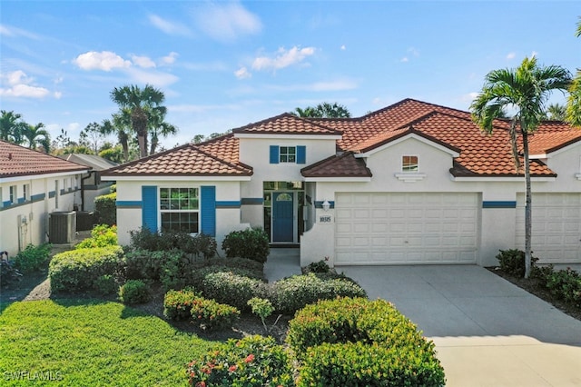 mediterranean / spanish-style home featuring central AC unit and a garage