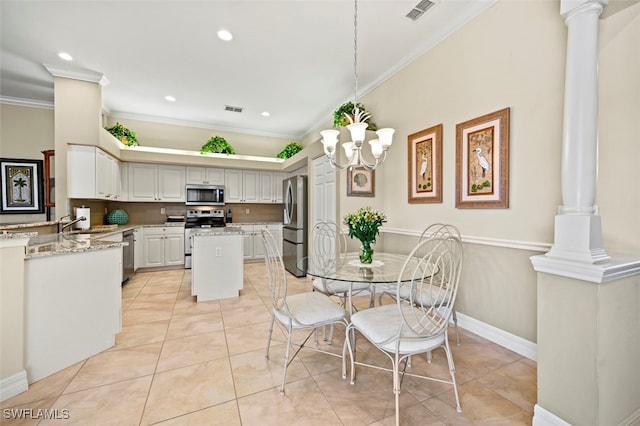 dining room featuring an inviting chandelier, ornamental molding, light tile patterned floors, and ornate columns