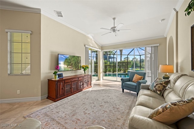 tiled living room featuring ceiling fan, ornamental molding, and vaulted ceiling