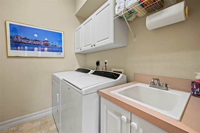 washroom featuring cabinets, sink, and washing machine and clothes dryer