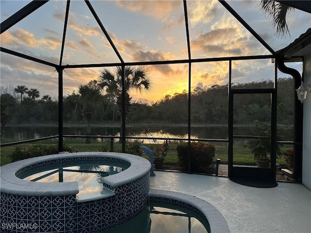 patio terrace at dusk with a water view and a lanai