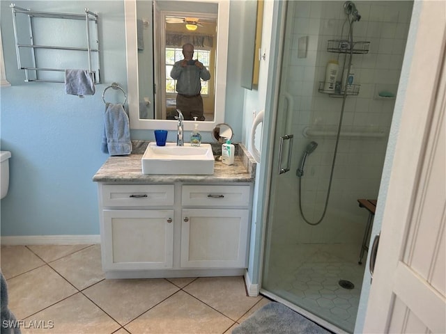 bathroom featuring a stall shower, tile patterned flooring, vanity, and baseboards