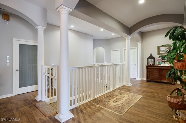 corridor featuring ornate columns and dark wood-type flooring