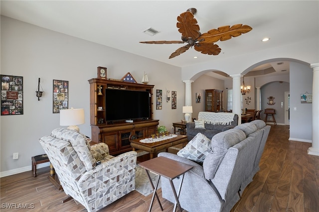 living room featuring decorative columns, dark hardwood / wood-style floors, and ceiling fan