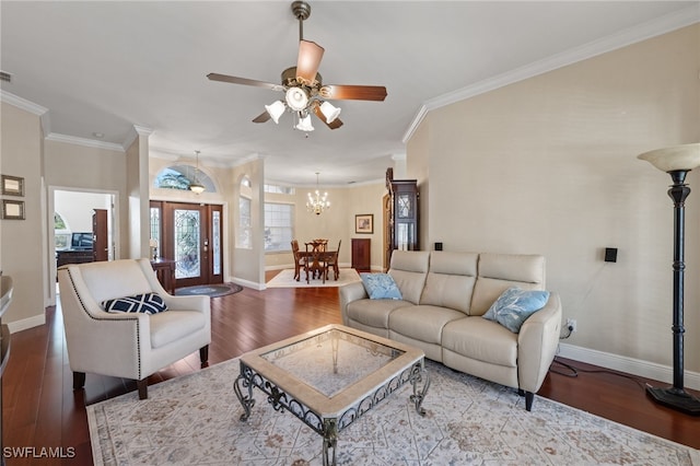 living room with ceiling fan with notable chandelier, baseboards, wood finished floors, and ornamental molding