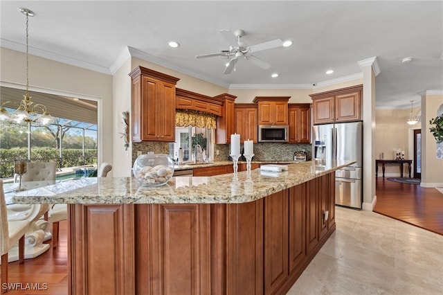 kitchen featuring light stone counters, a breakfast bar, decorative light fixtures, stainless steel appliances, and brown cabinetry