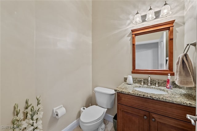 half bath with toilet, baseboards, and vanity