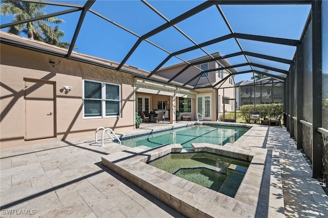 view of pool with glass enclosure, a patio, and a pool with connected hot tub