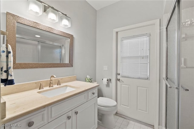 bathroom featuring toilet, a shower stall, vanity, and tile patterned floors