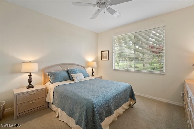 bedroom featuring light carpet, a ceiling fan, and baseboards