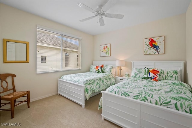 bedroom with light colored carpet, ceiling fan, and baseboards